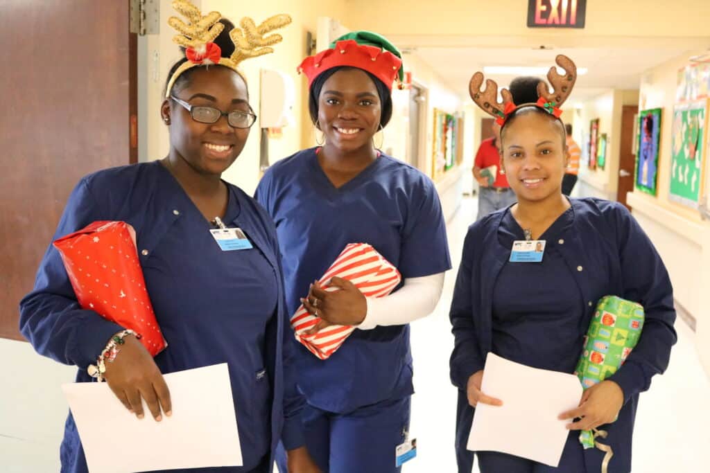 Med-Asstg-students-Ariel-Collins-Elisabelle-Polynice-Breanna-Crosby-bearing-gifts